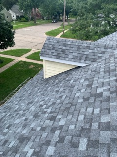 A completed roof installation on a luxury home with designer shingles
